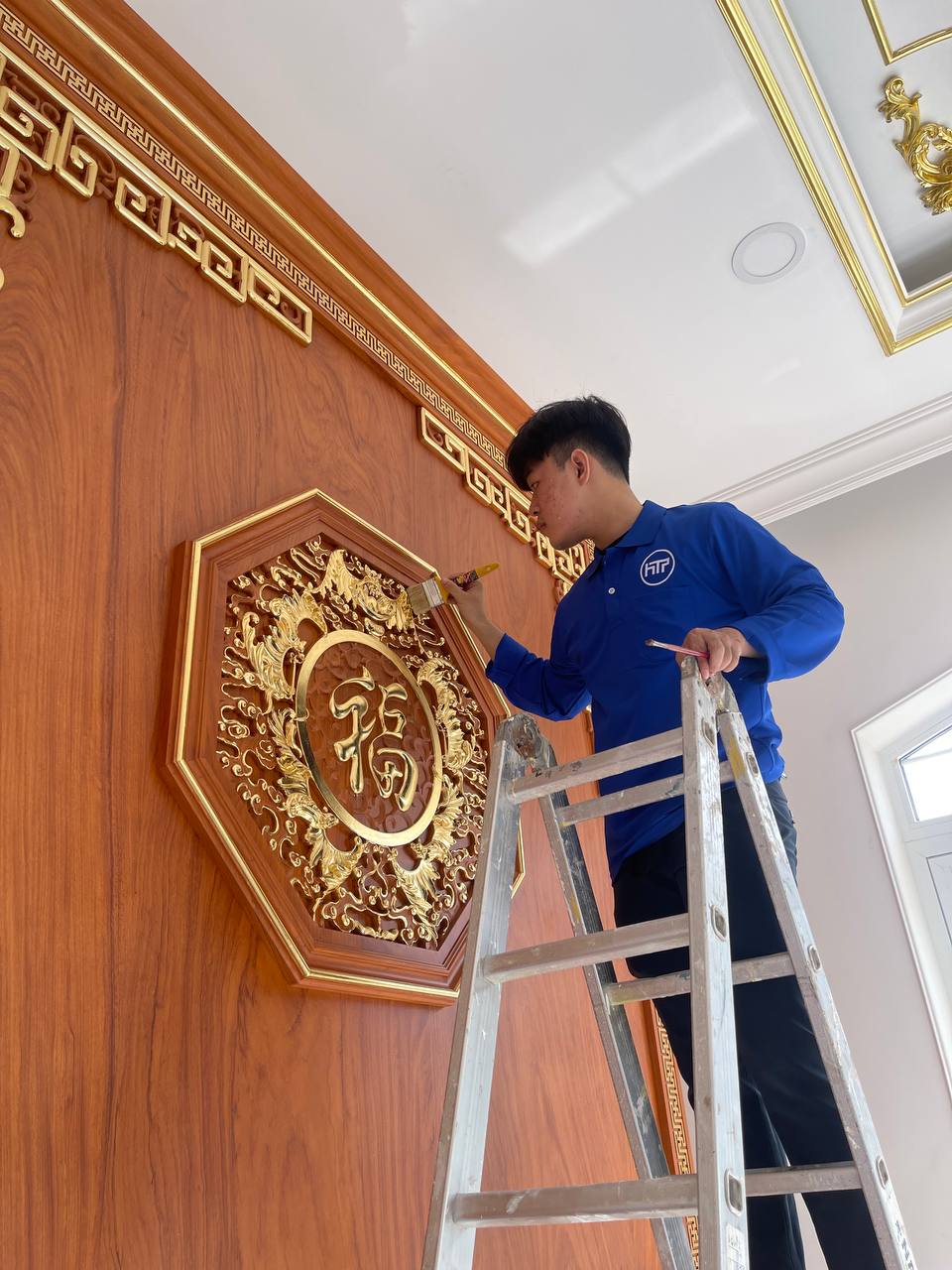 Nghệ nhân đang thực hiện công đoạn dát vàng phù điêu chữ Phúc.