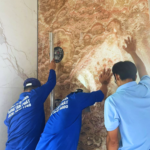 Đội thợ đang phối hợp lắp đặt tấm đá Onyx vàng vân gỗ khổ lớn.